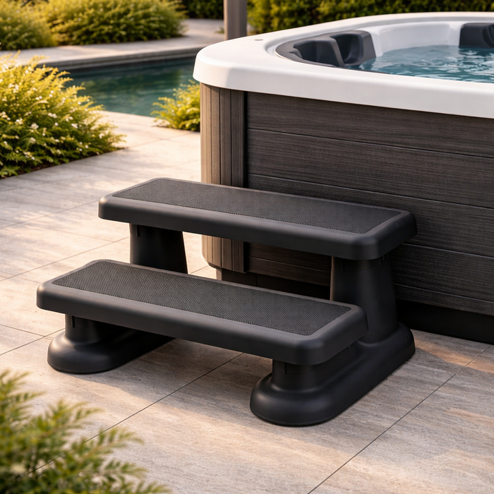 Black two-step spa steps beside a luxury spa pool on premium outdoor paving