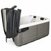Spa cover lifter holding a folded cover beside a spa