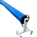 Blue solar swimming pool cover rolled onto a wheeled roller