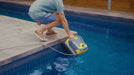 Zodiac CX-series robotic pool cleaner being lifted from a swimming pool