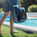 Zodiac FR350 iQ cordless pool cleaner being carried beside a swimming pool